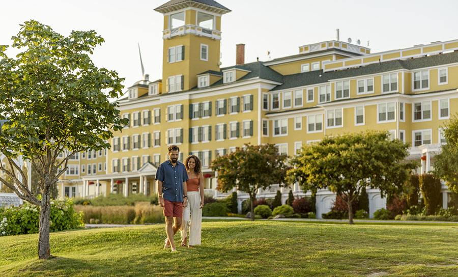 a couple outside a large yellow resort
