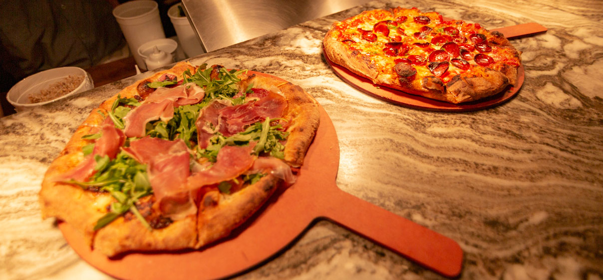 2 pizzas on cutting boards