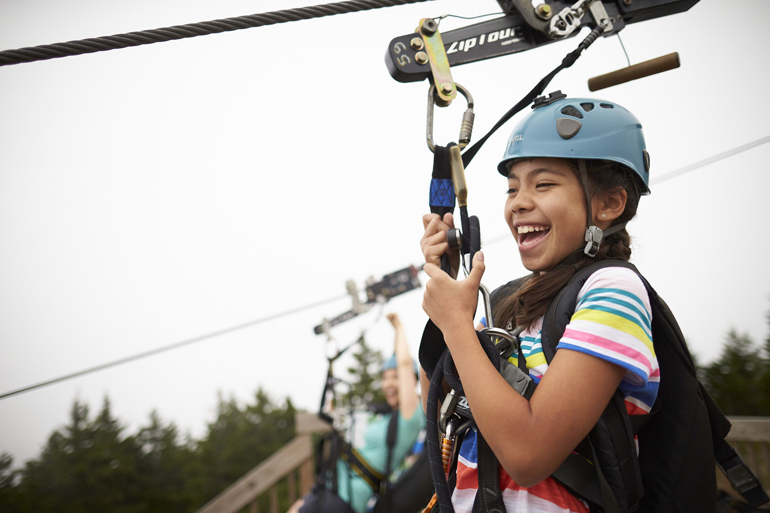 little girl ziplining down a mountain