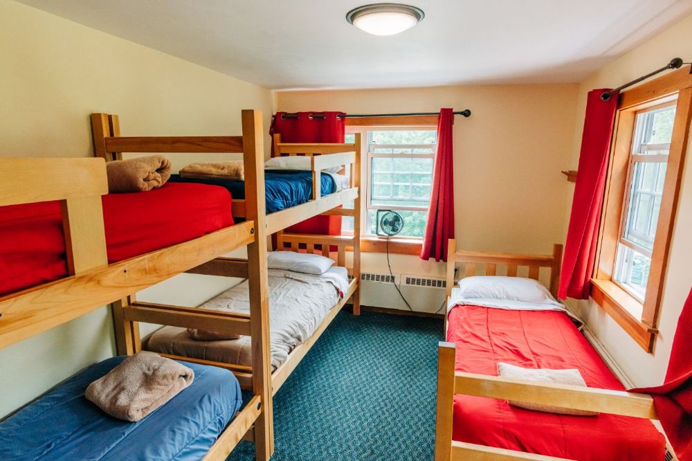 Private rooms with bunks and queen beds available. Linens included. Shared bath with showers. Photo by Corey David Photography