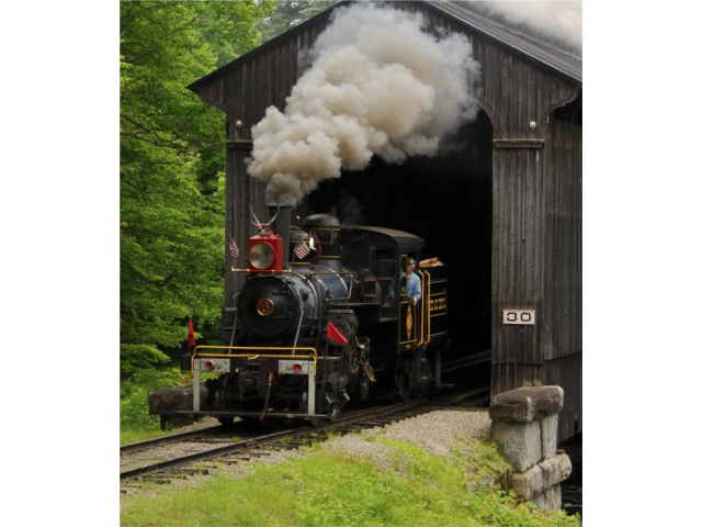 1920 Climax locomotive steaming through authentic railroad covered bridge