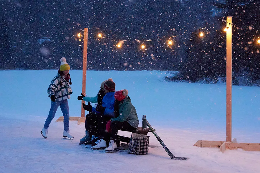 Family sitting on a bench taking a break from ice skating