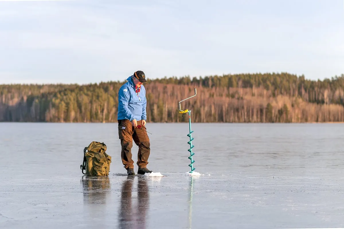 Man drilling an ice fishing hole