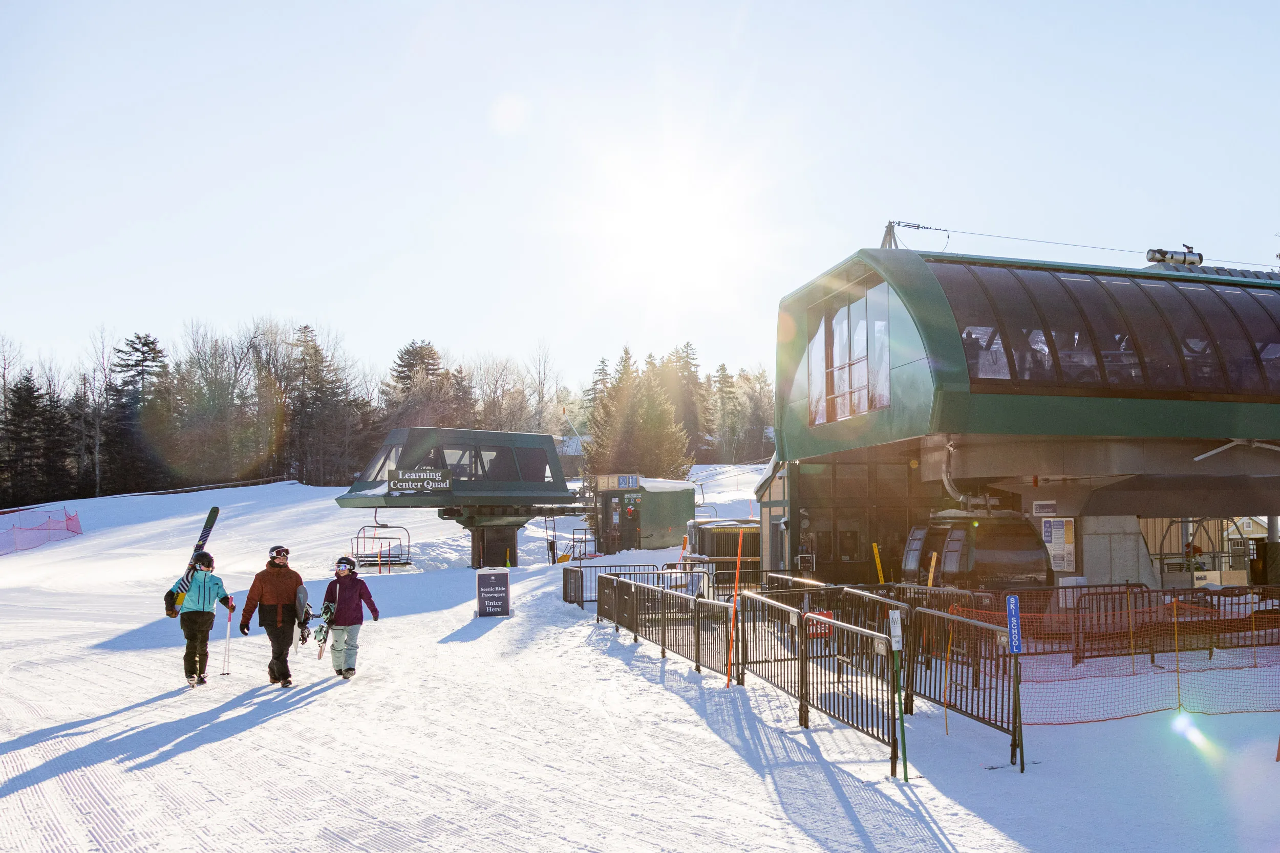 Skiers walking past ski ski lift